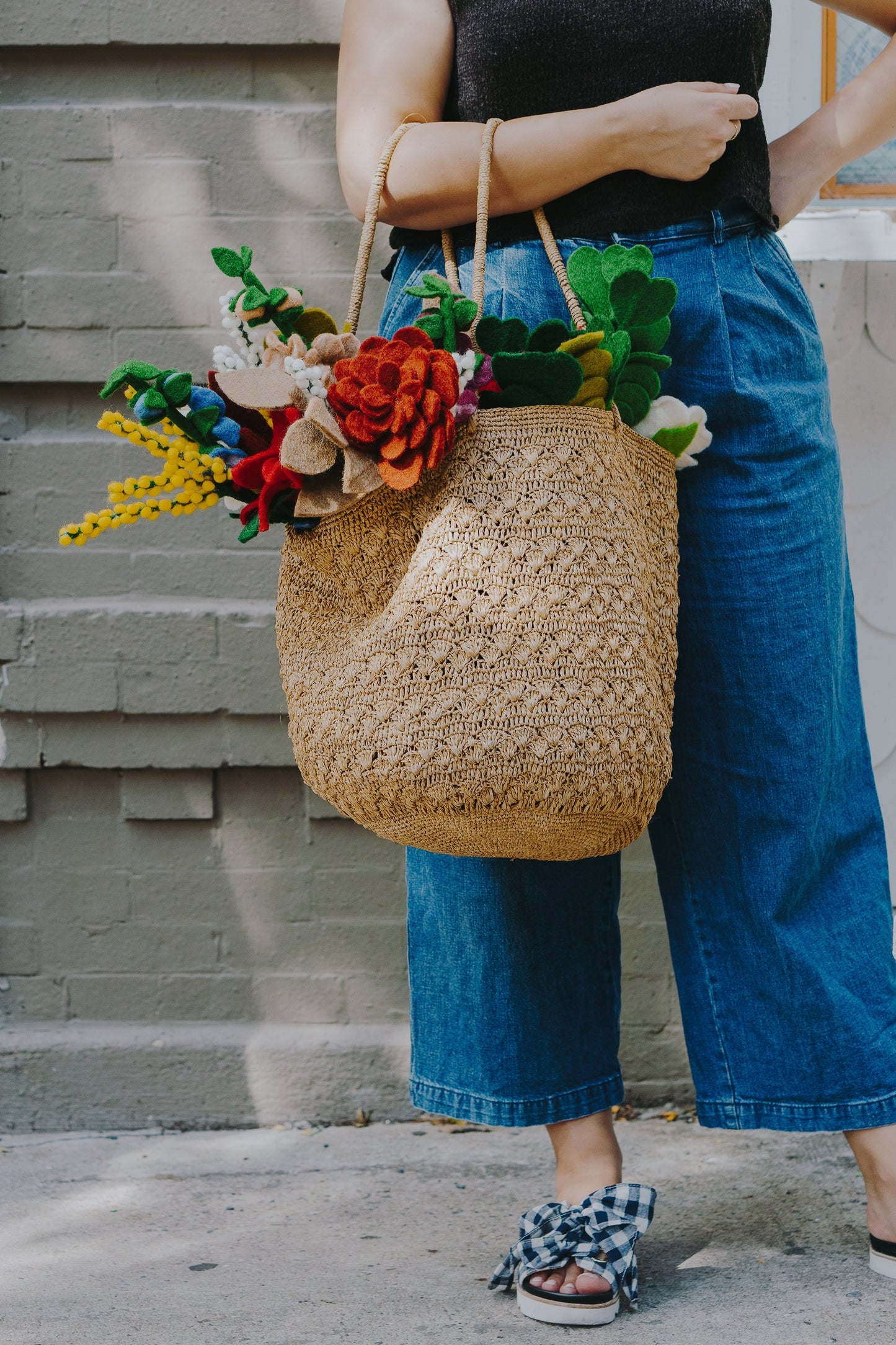 Yellow felt Baby's Breath flowers in tan woven bag with other various felt flowers.