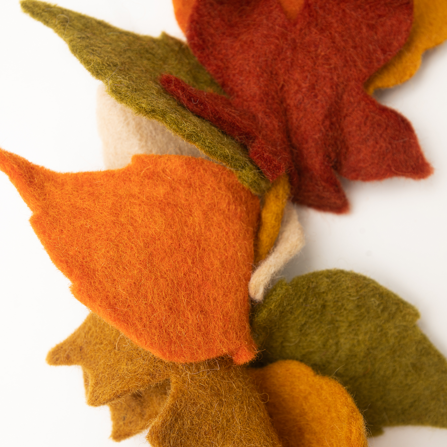Close up of felt garland of fall Maple leaves in red, orange, yellow, and green.
