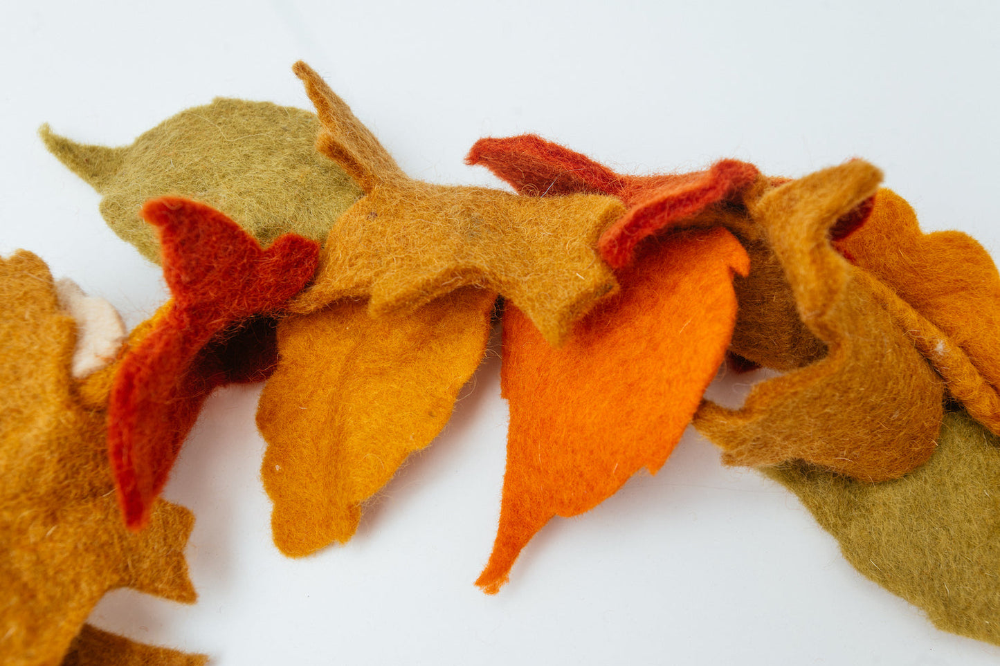 Close up of felt garland of fall Maple leaves in red, orange, yellow, and green.