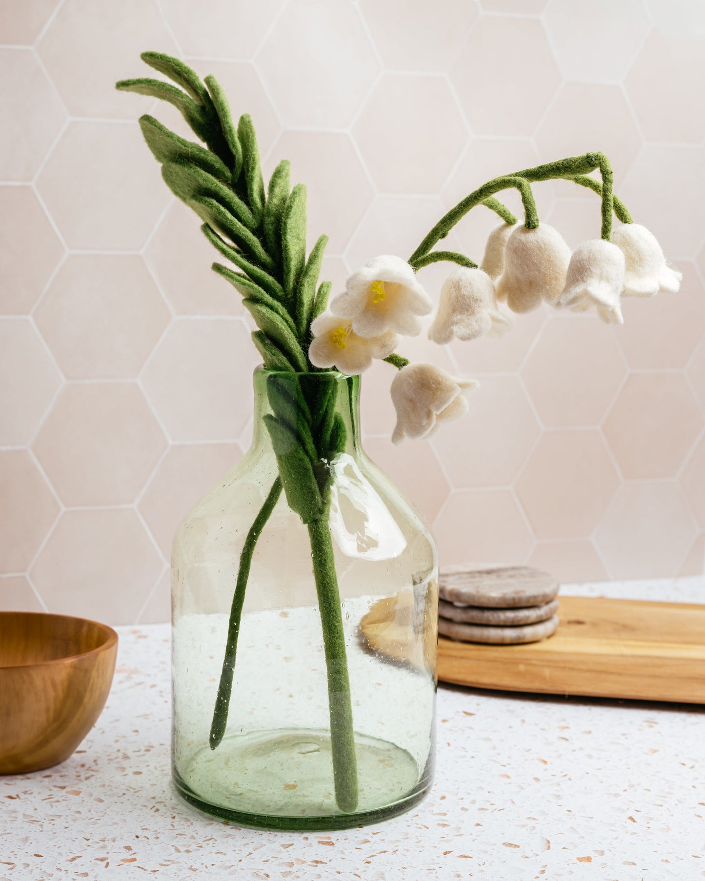 Felted white lily of the valley flower in glass vase.