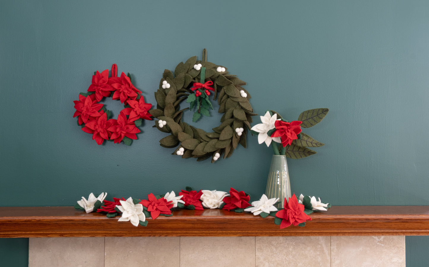 Felt ornament of Holly with berries and a red bow hanging with various wreaths.