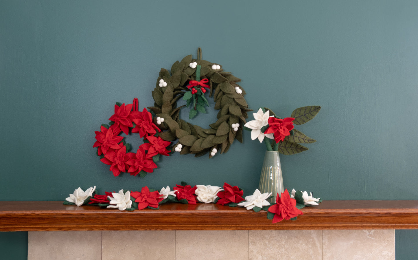 Felt ornament of Holly with berries and a red bow hanging with various wreaths.