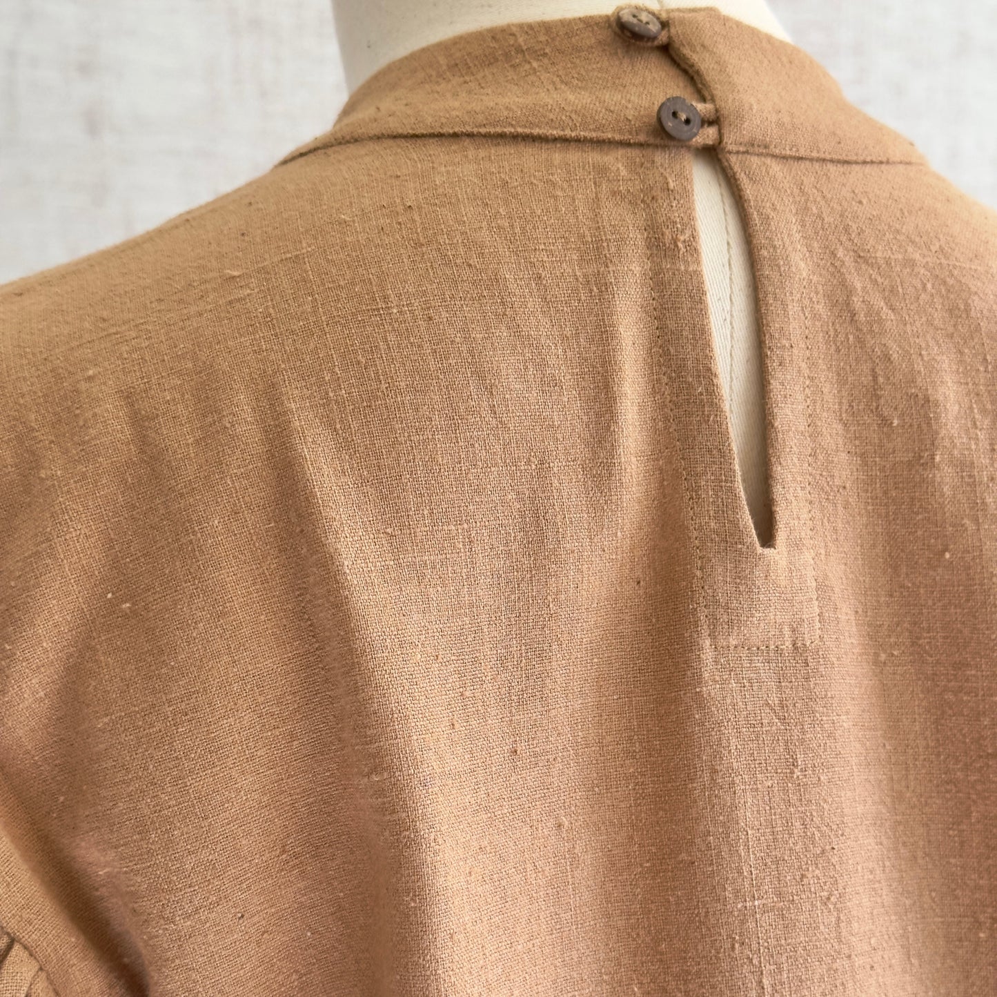 Back view of brown woven long sleeve shirt with button closure.