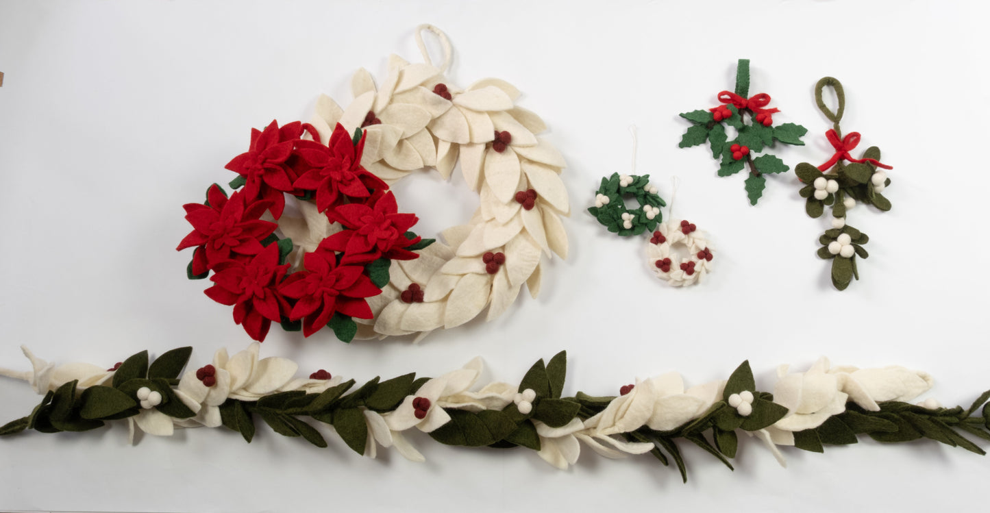 Various felt green, red and white wreaths and garlands laid out.