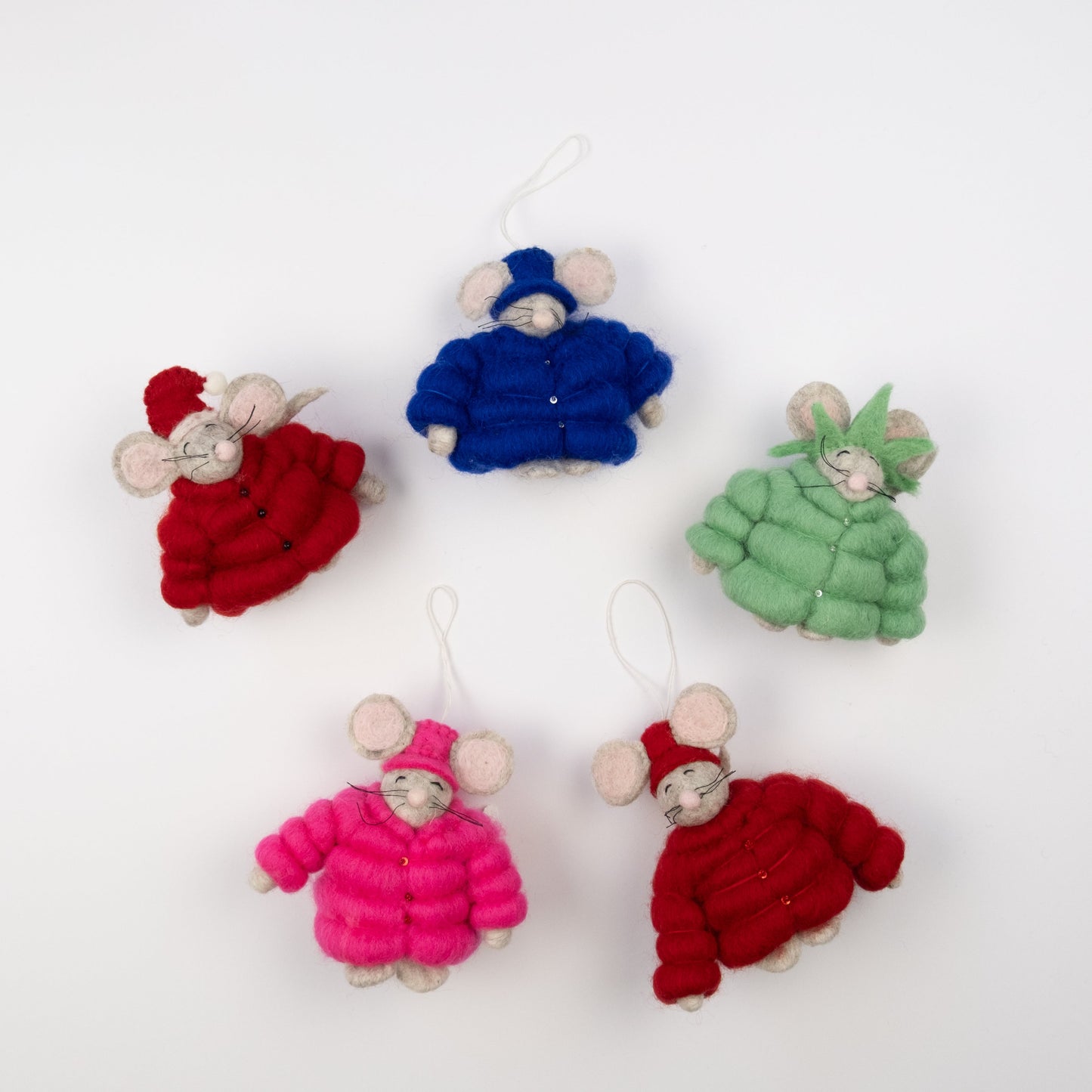 Felt ornaments of mice in pink, red, blue, green and red puffer jackets and various hats or crowns laying in a circle.