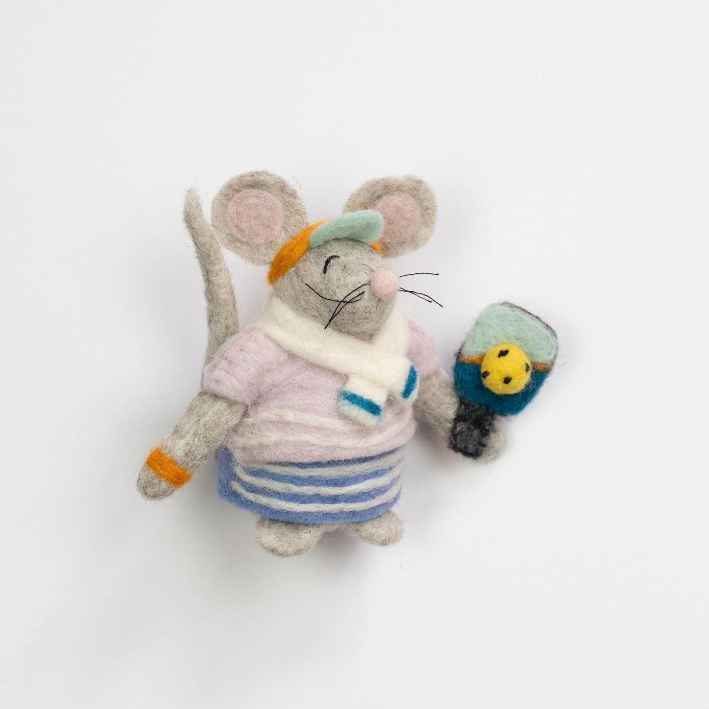 Felted ornament of a mouse dressed in a retro striped sweater, matching skirt, bright orange visor, and tiny sweatbands, with a pickleball paddle and ball in paw.
