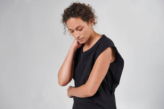 Closeup of woman wearing black short sleeve top.