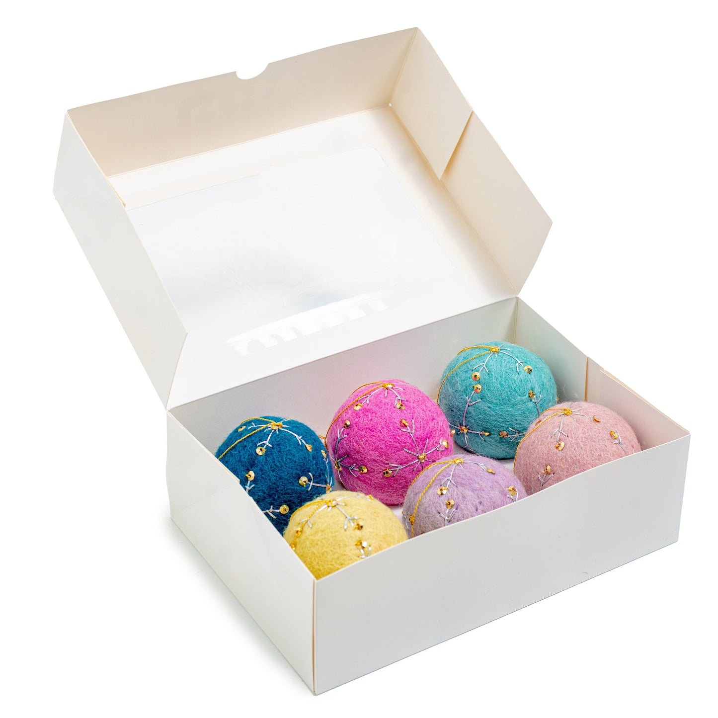 A white box of round felt ornaments with gold sequin and embroidery designs in dark blue, bright pink, teal blue, yellow, and light pink.