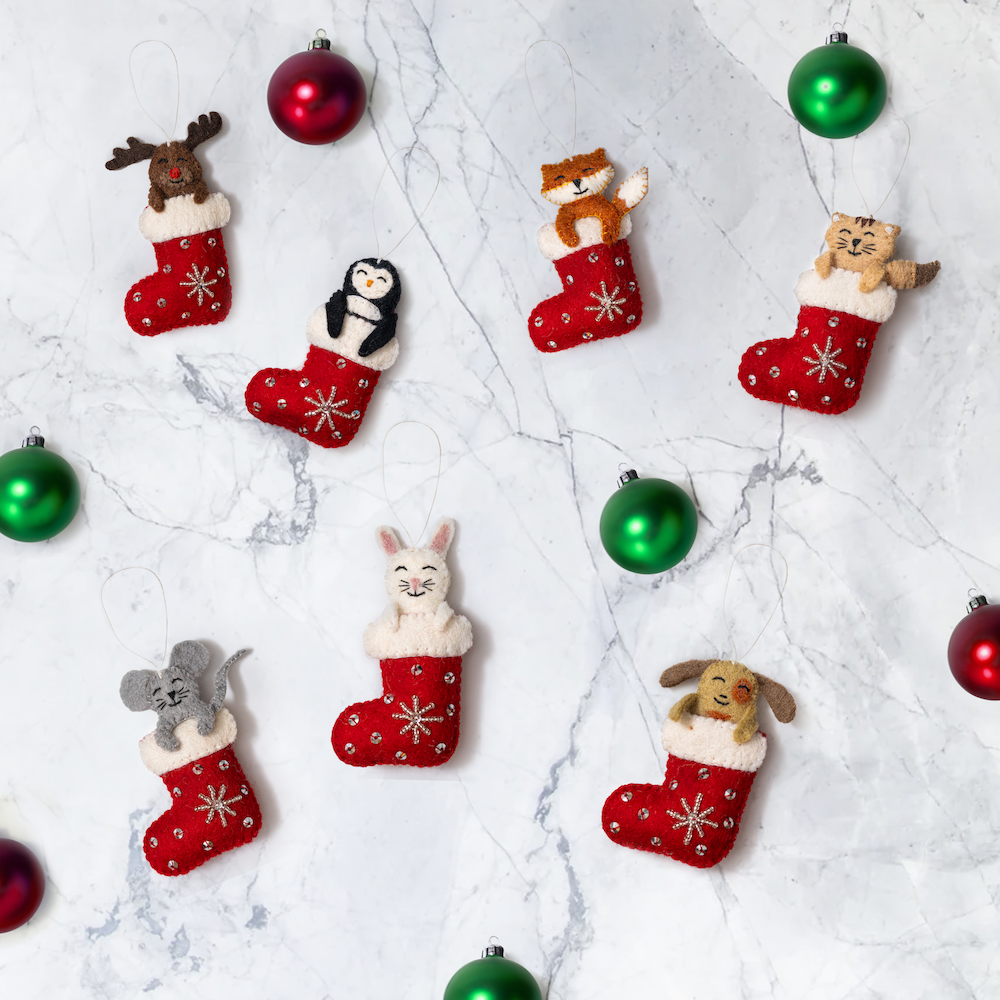 Scattered felt ornaments of various animals sticking out of red and white Christmas stockings.