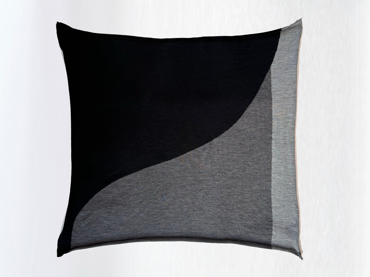 Scarf in black, charcoal, and light grey folded in a square.