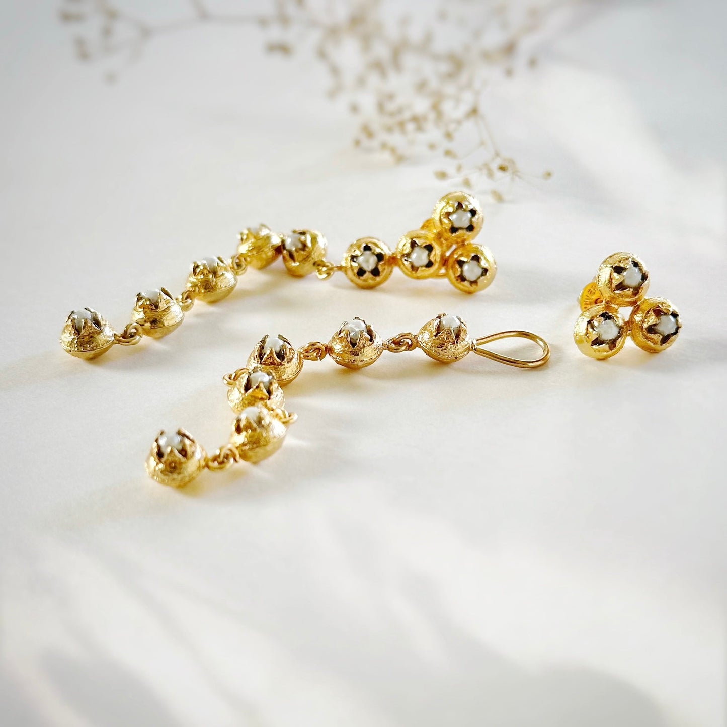 Pair of gold dangle earrings with five discs each and pearl glass in each disc.