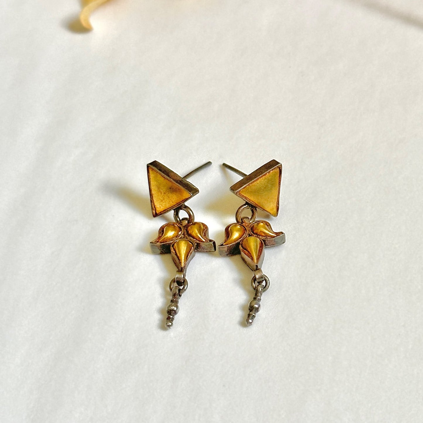 Pair of gold foil earrings with geometric design.