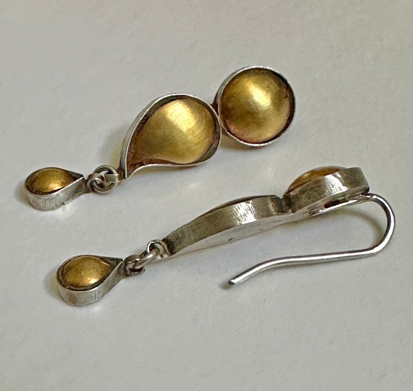 Pair of gold foil earrings with tribal design.