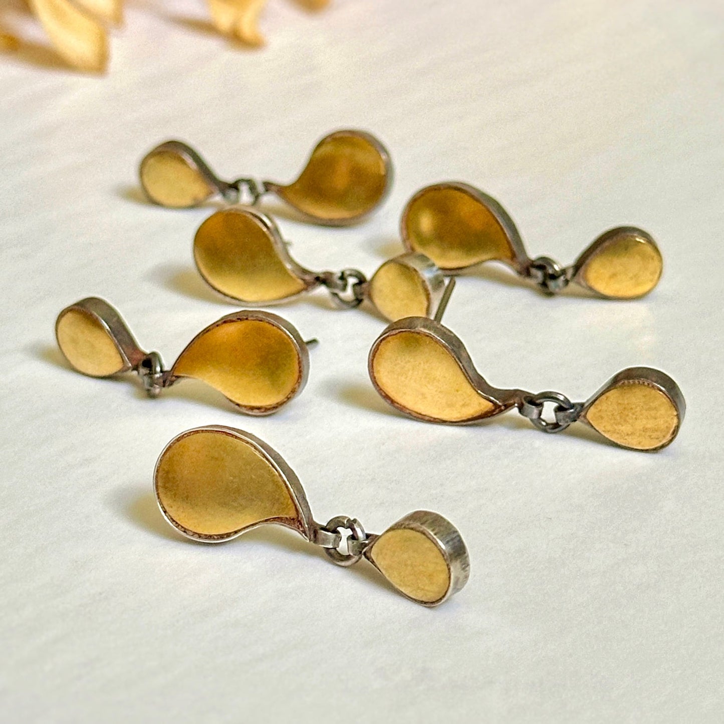 Grouping of gold foil earrings with tribal design.