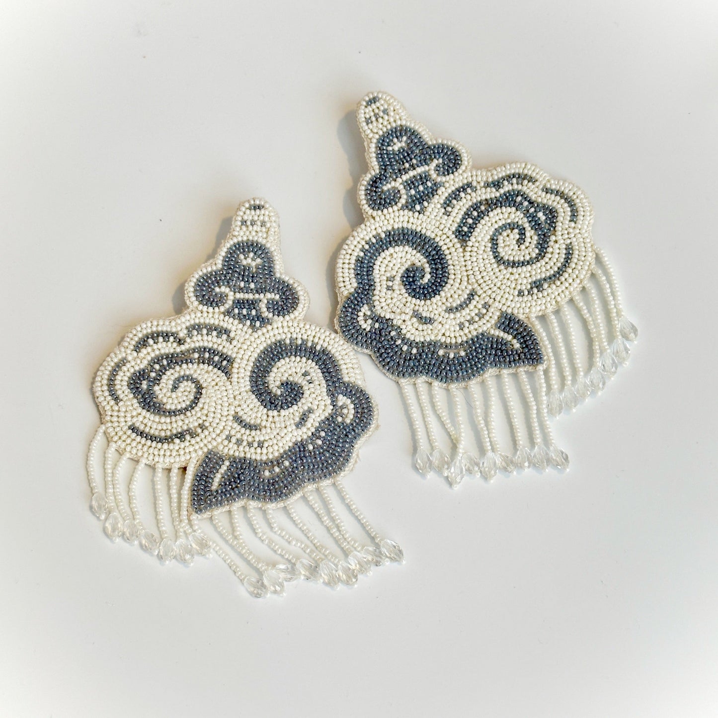 Pair of white and black cloud earrings with tassels.