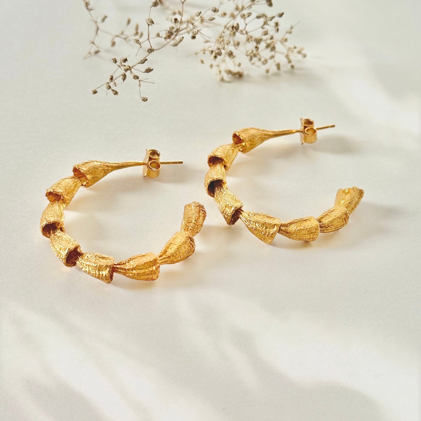 Pair of gold hoop earrings.