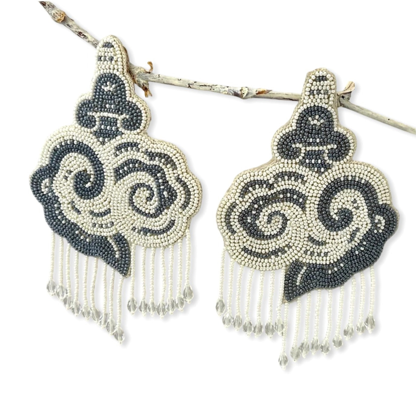 Pair of white and black cloud earrings with tassels.