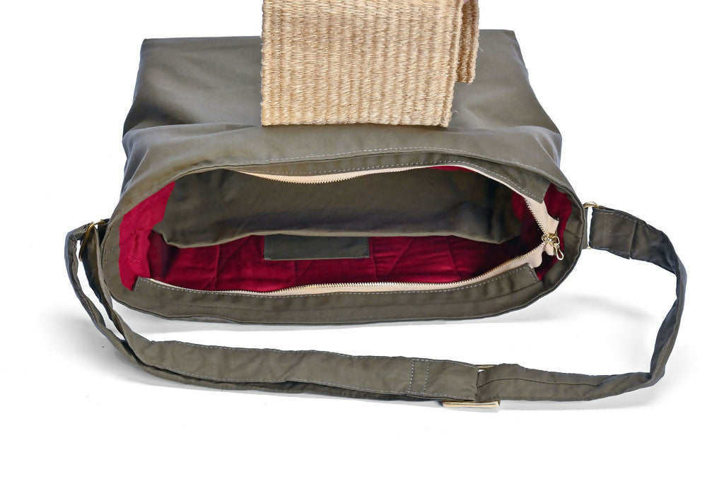Open flat view of olive green bag with sisal details and inside red lining.