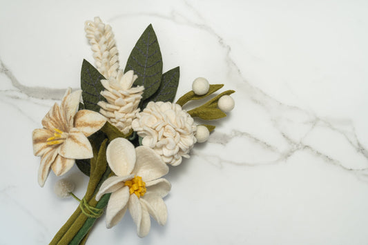 Winter white felt flower arrangement on a marble surface. Fair trade and handmade by women artisans in Nepal