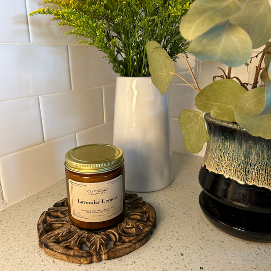 Lavender lemon candle in amber jar on a white countertop.