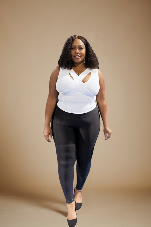 Woman wearing white waist length crop top with black pants and shoes.