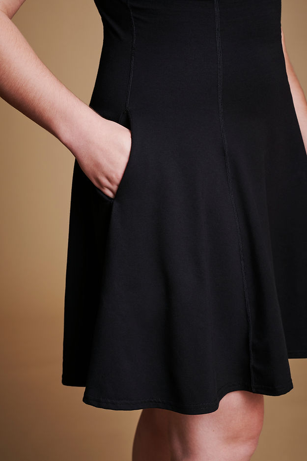 Closeup of pockets on black flare dress.