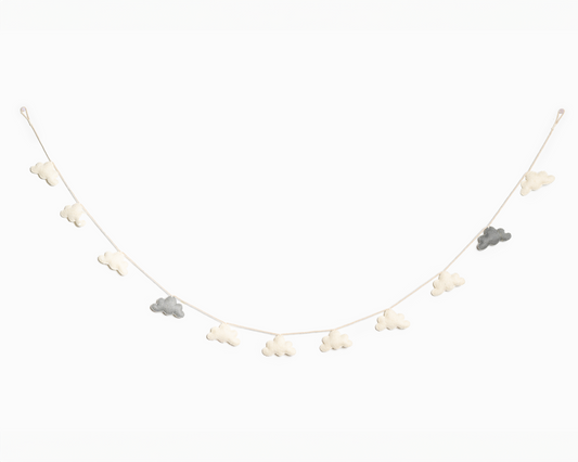 Grey and white felt cloud garland hanging on a white wall.