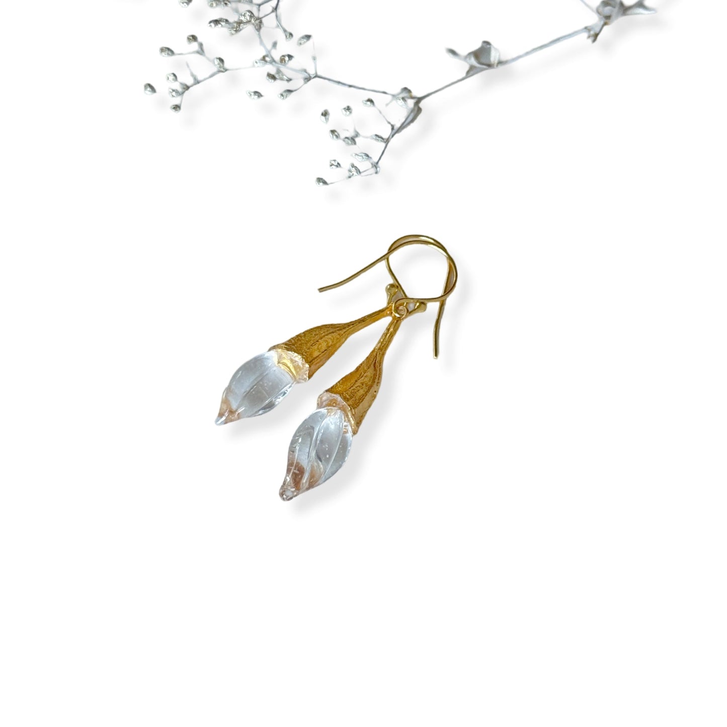 Pair of clear twisted glass bud earrings with gold findings.