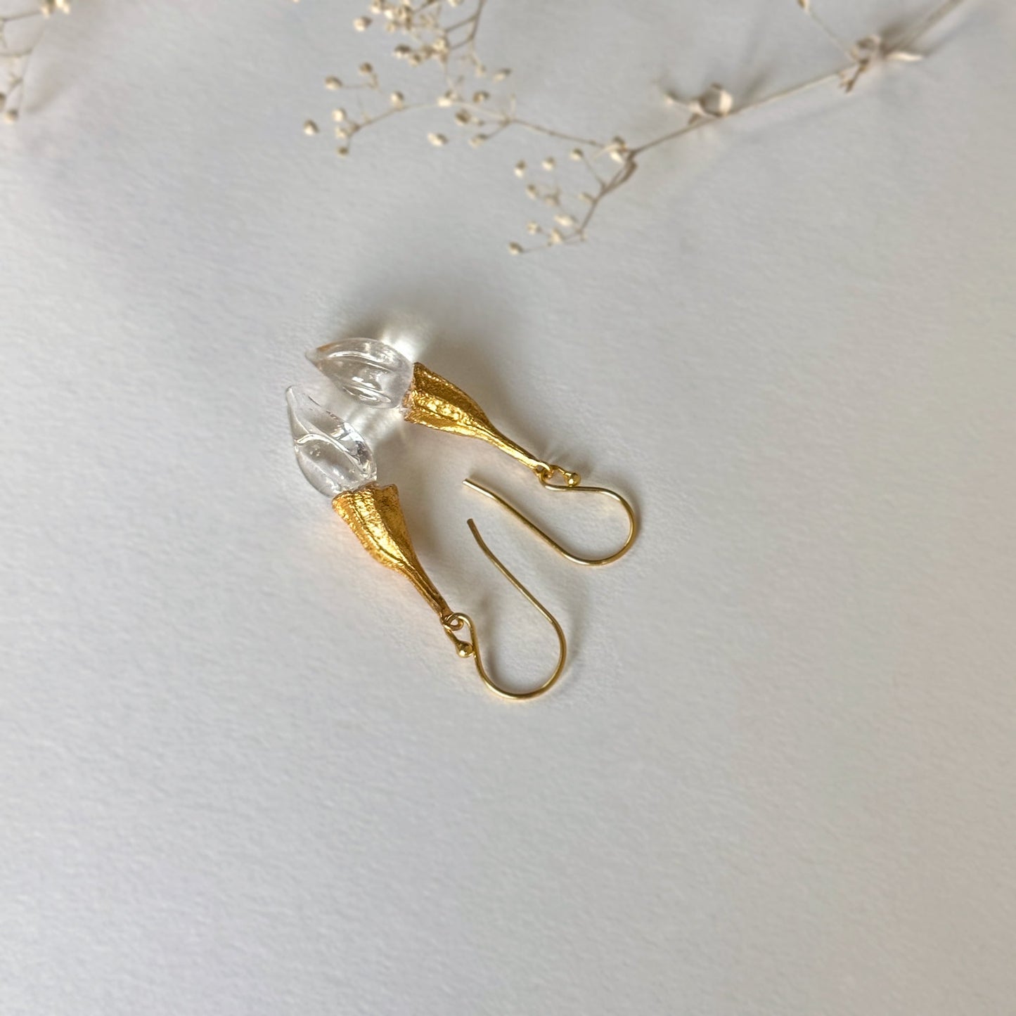 Pair of clear twisted glass bud earrings with gold findings.