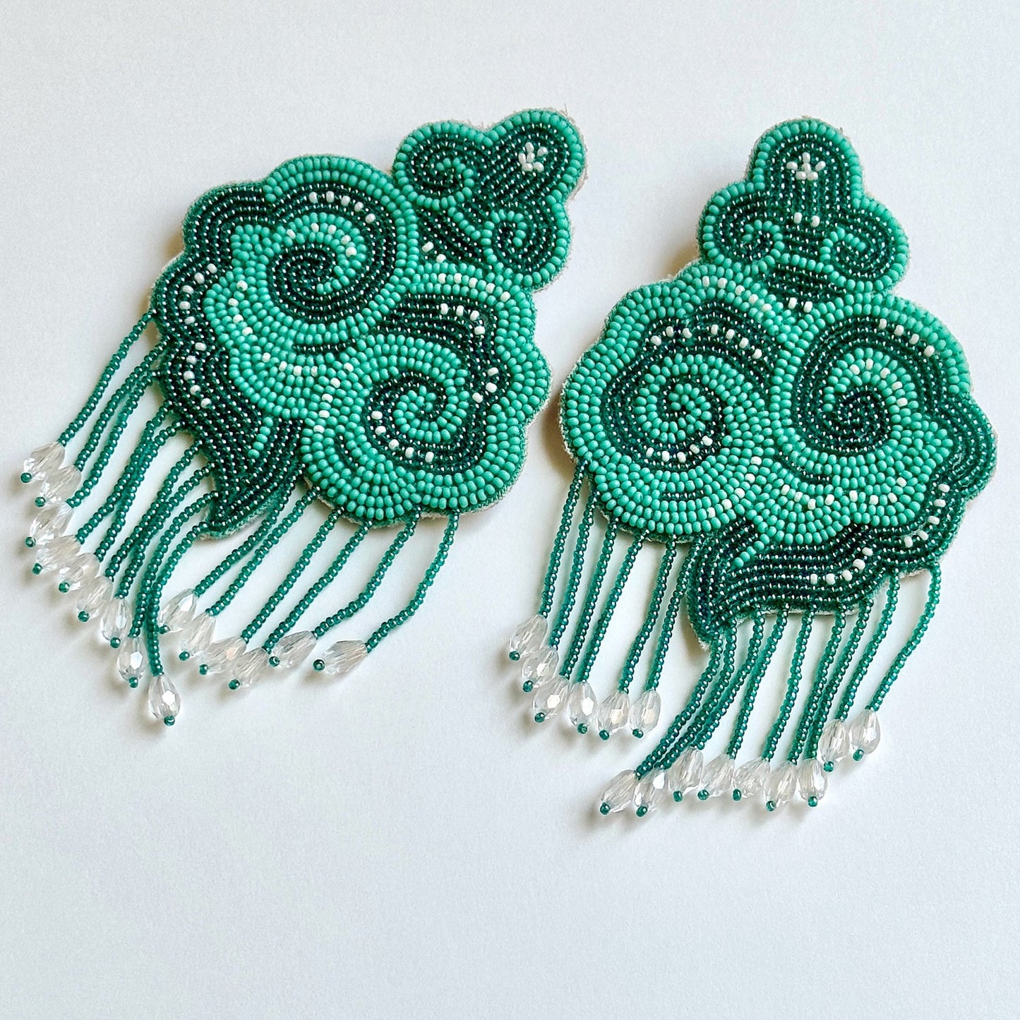 Pair of light and dark green cloud earrings with tassels.