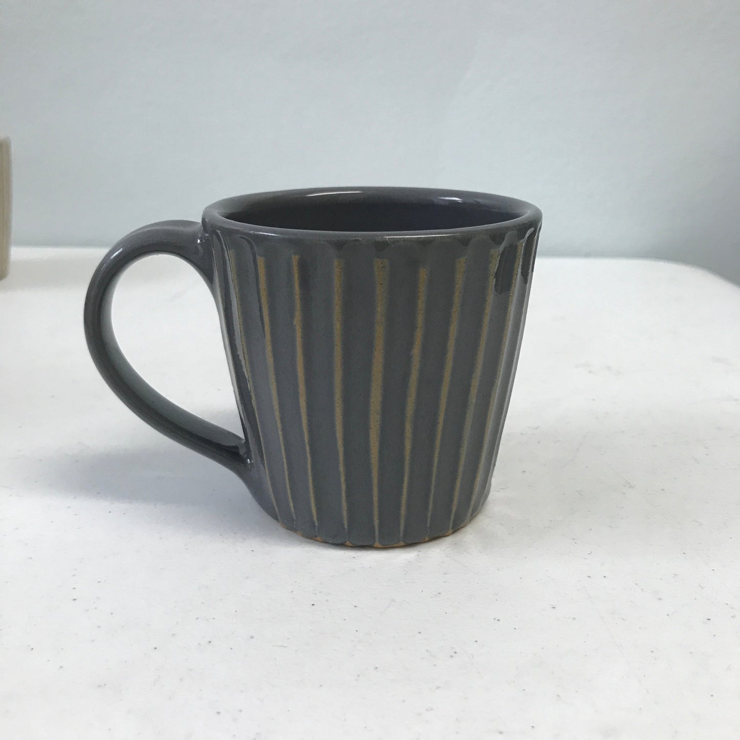 Stone colored mug with handle.