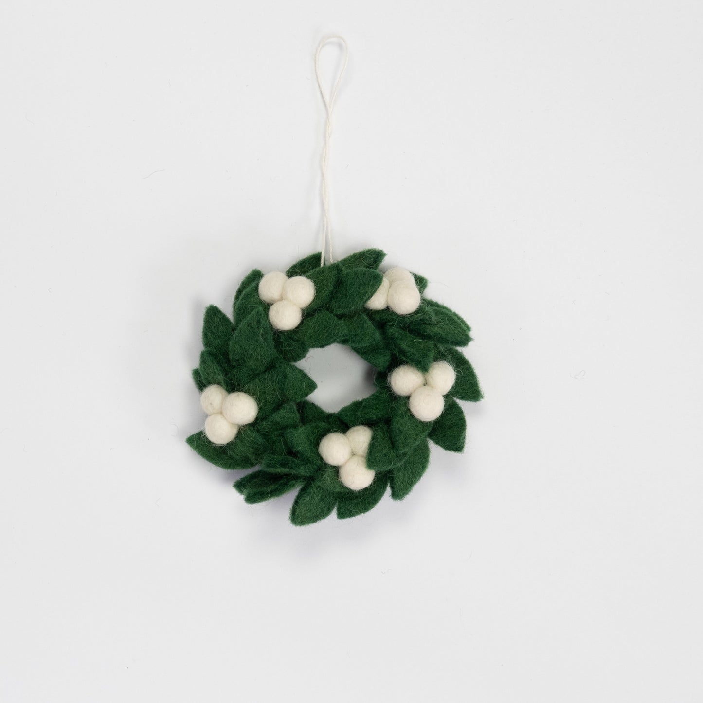 Felt ornament of mini wreath in green with white berries.