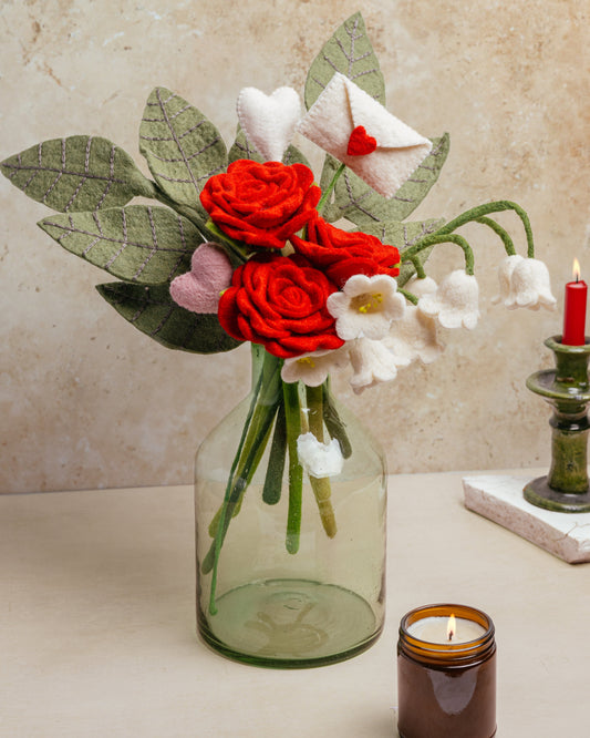 Felt red and white flower bouquet with accent stem of white envelope with red heart sealing the envelope.