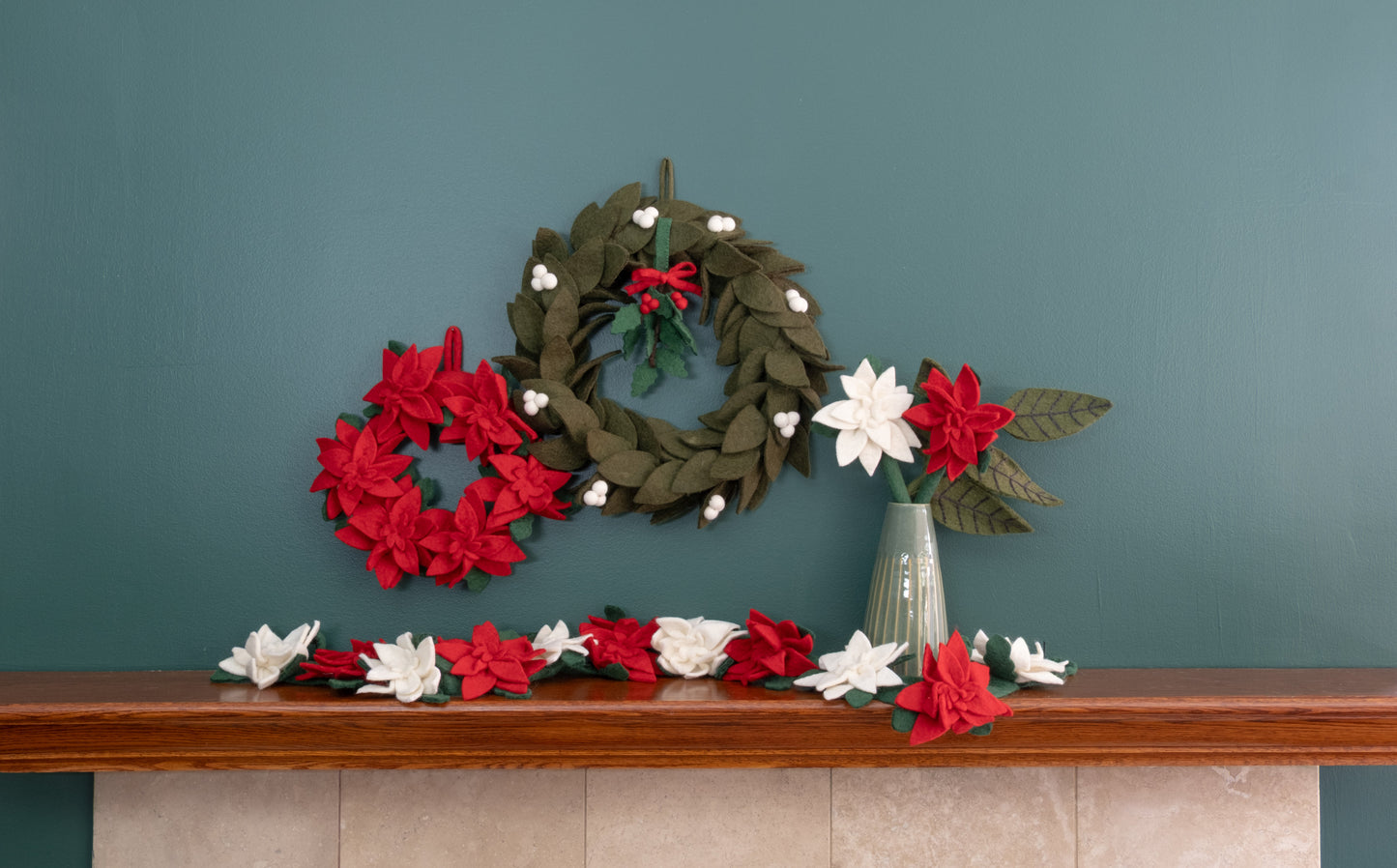 Felt ornament of Holly with berries and a red bow hanging with various wreaths.