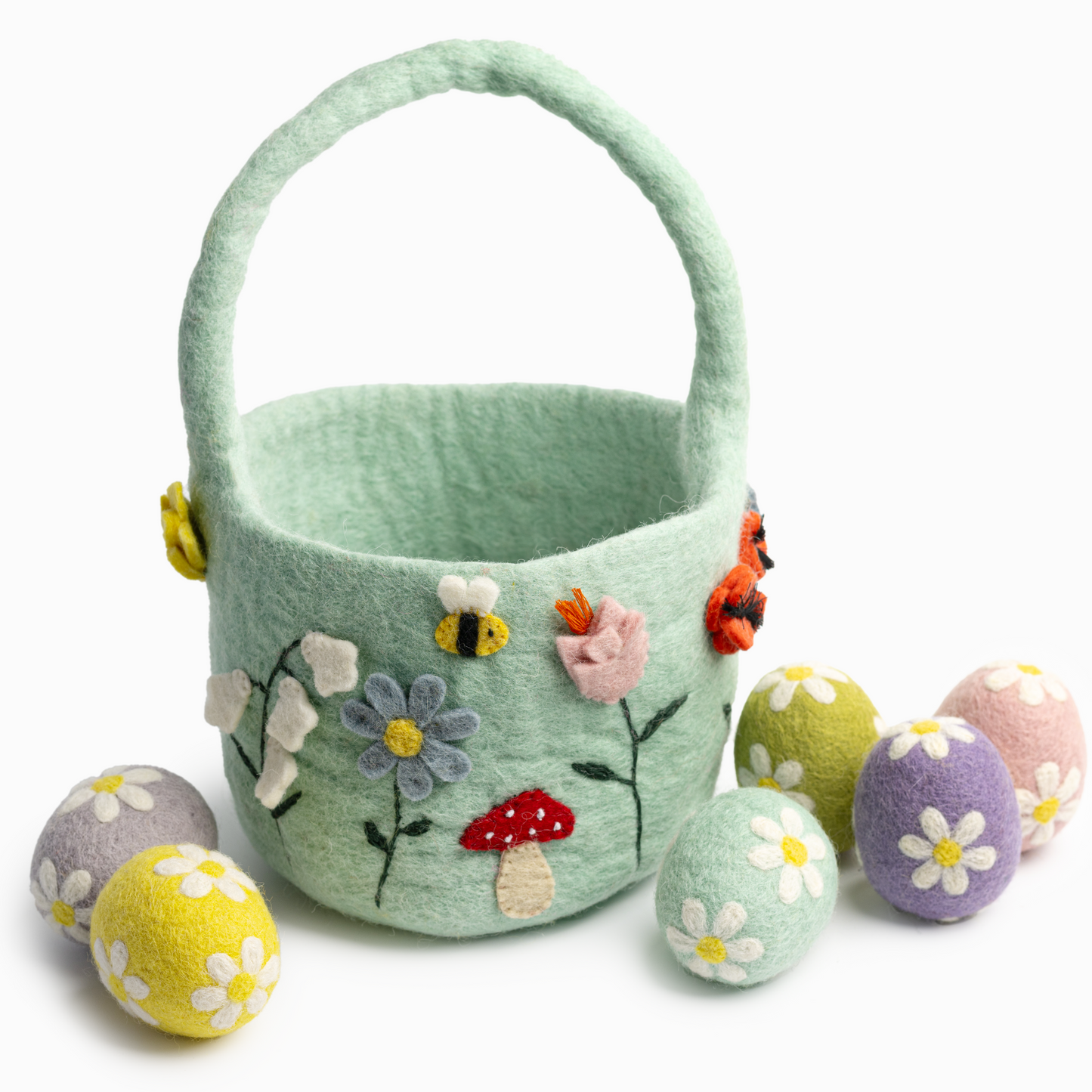 Light green felt easter basket with flowers and bees and felt easter eggs scattered around.