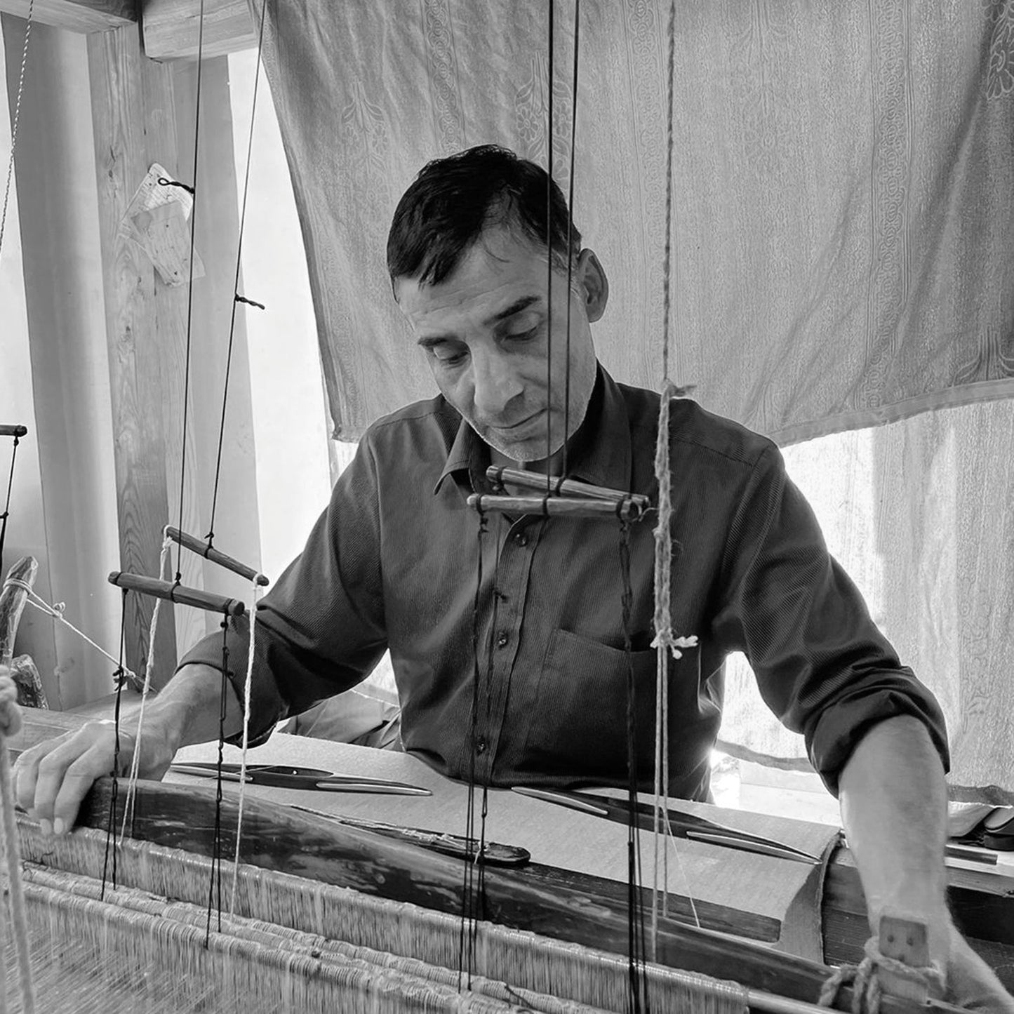 Artisan working on loom.