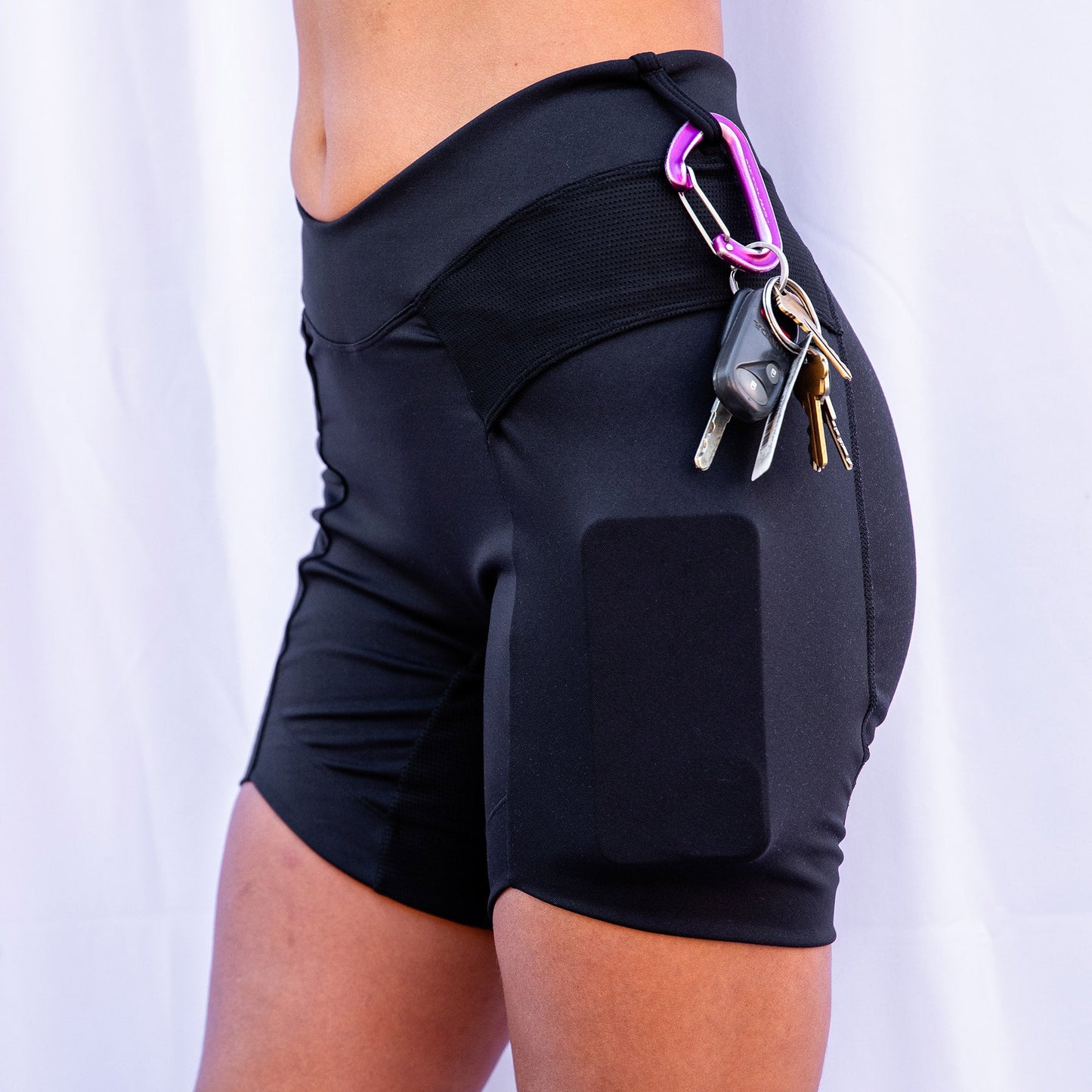Closeup of black toura short with carabiner and keys hanging from short loop.