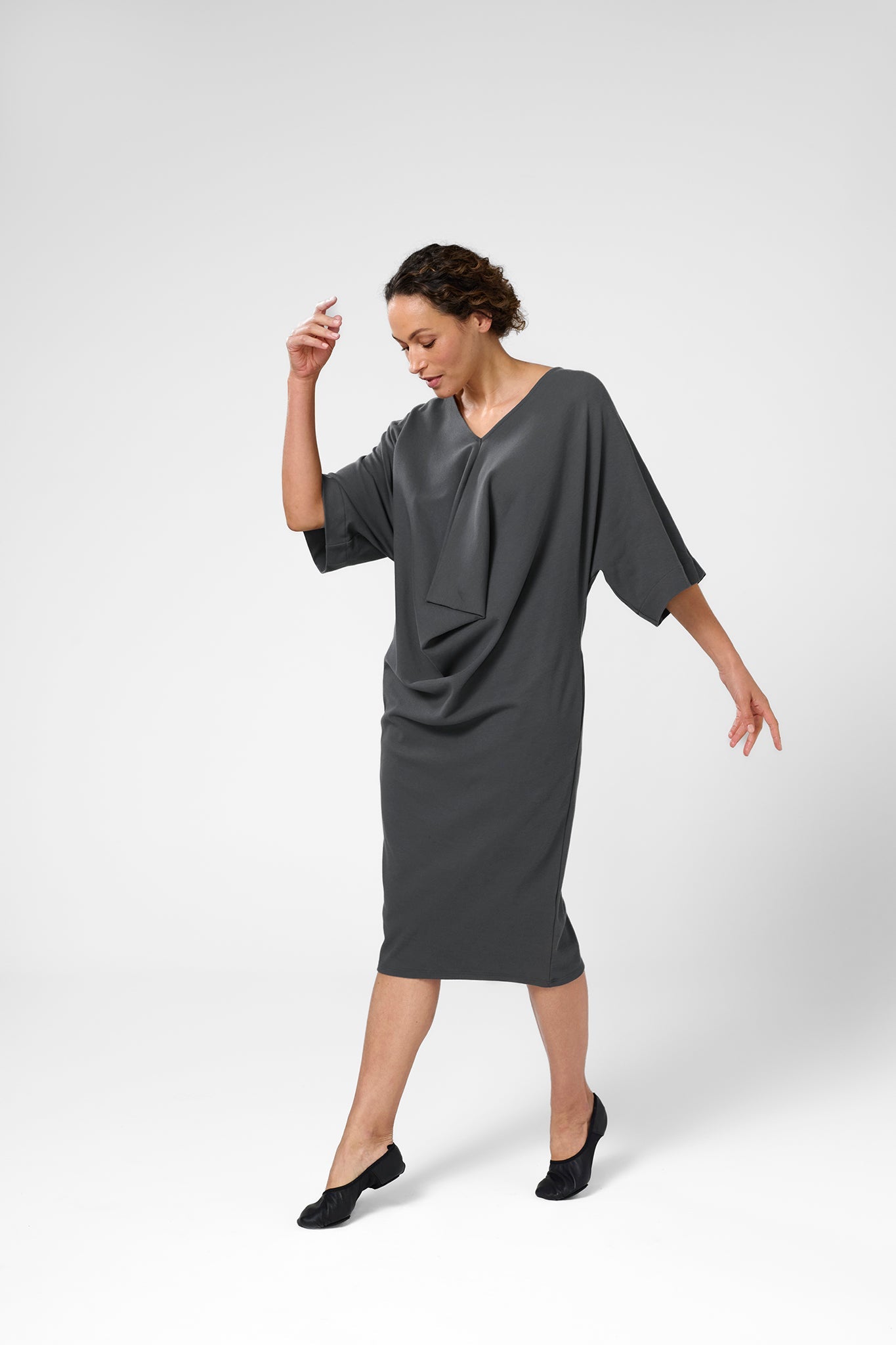 Woman wearing knitted Orbis dress in iron color.