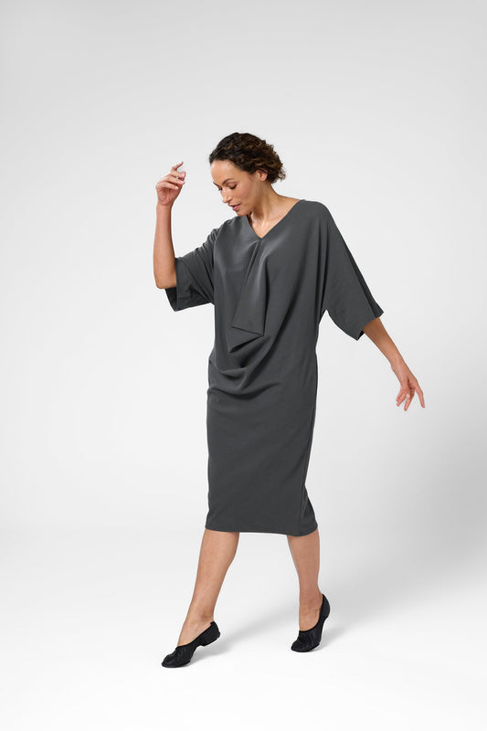 Woman wearing knitted Orbis dress in iron color.