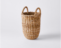 Tall circular brown woven basket with handles.