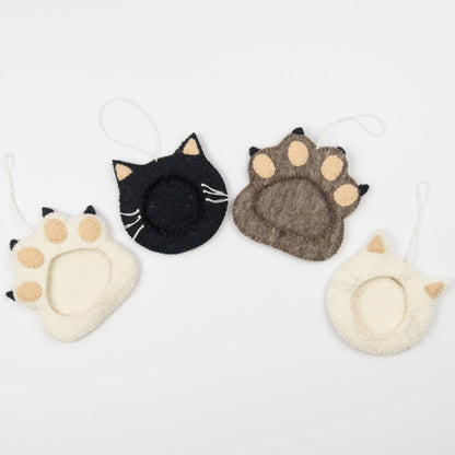 Felt ornaments of a white pawprint, a black cat, a brown pawprint, and a white cat all with a frame in the middle to put a photograph.