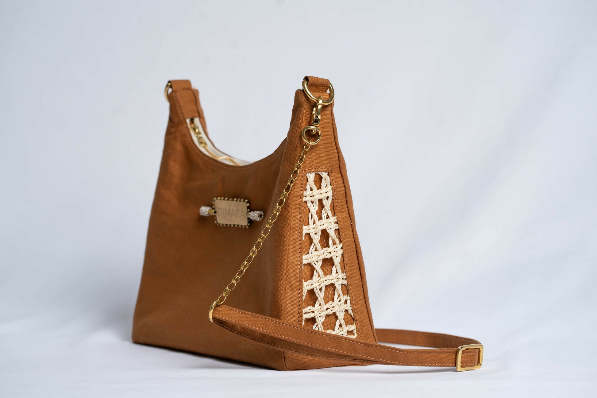 Brown leather handbag with woven sisal sides, chain and leather strap.