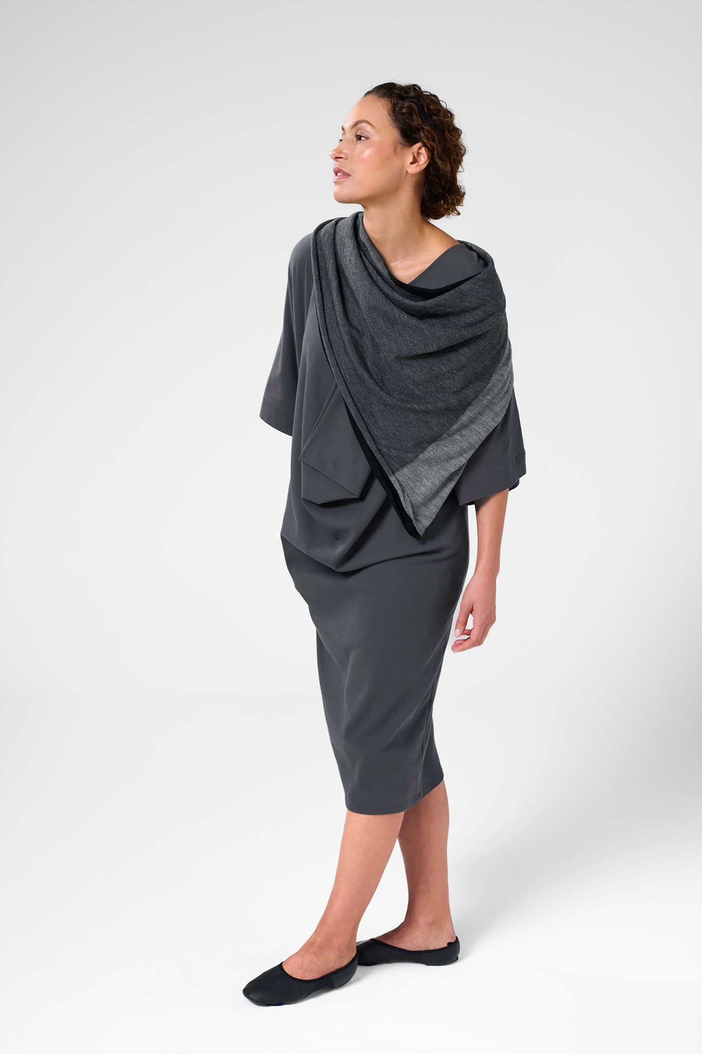 Front left view of woman wearing scarf in black, charcoal, and light grey.