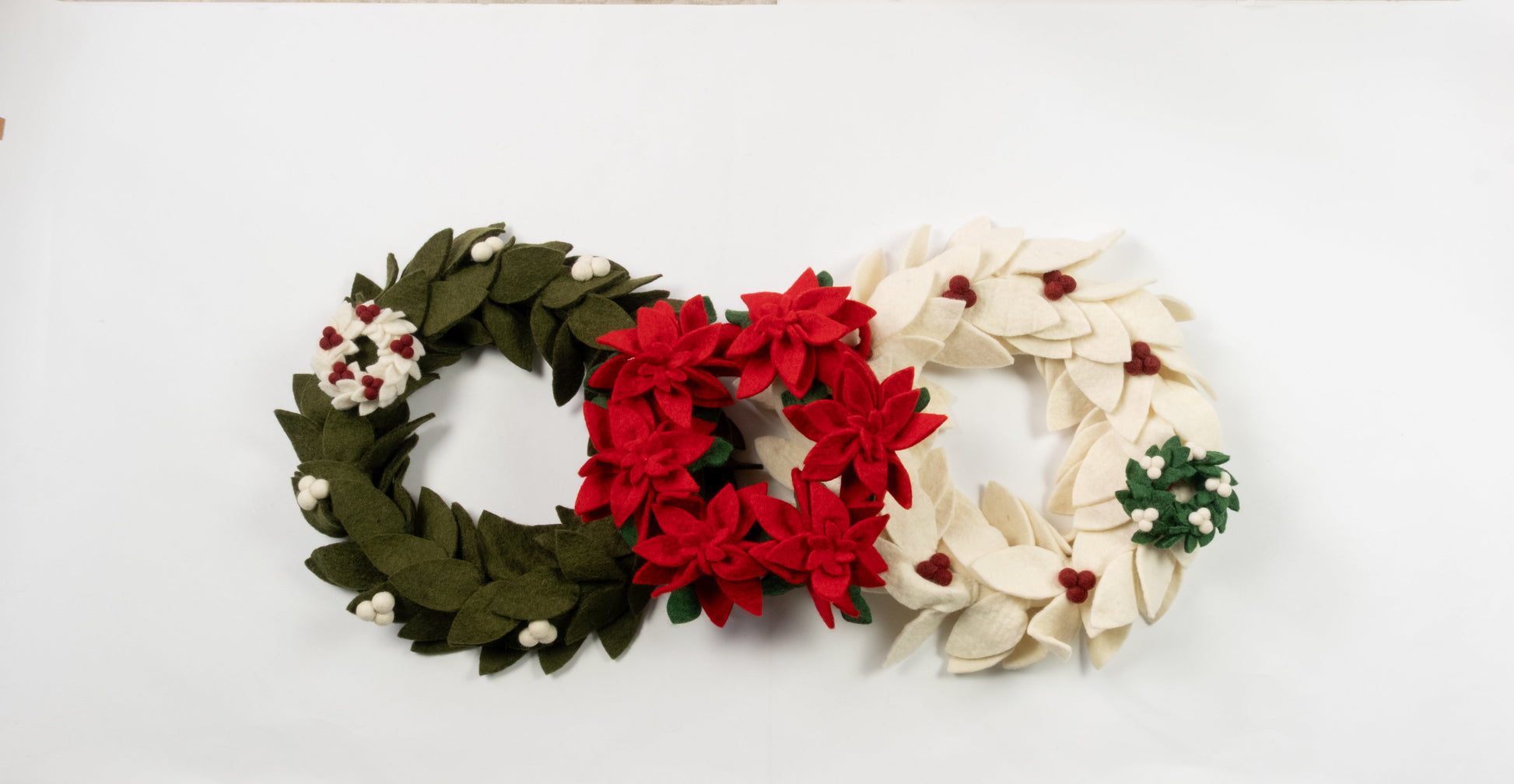 Felt ornaments of mini wreaths in green, red, and white.