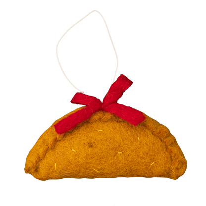 Felt ornament of an empanada with a red bow on top.