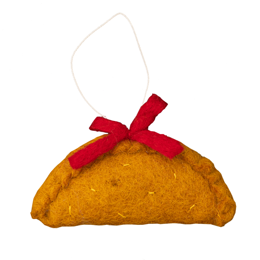 Felt ornament of an empanada with a red bow on top.