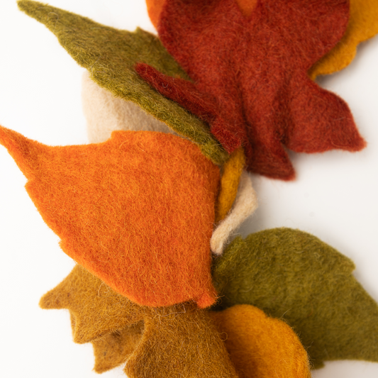 Close up of felt garland of fall Maple leaves in red, orange, yellow, and green.