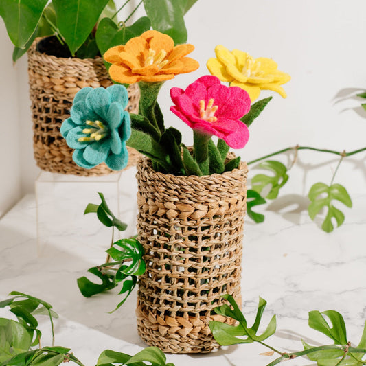 Blue, orange, yellow, and pink felt Camellia flowers in woven hogla vase.