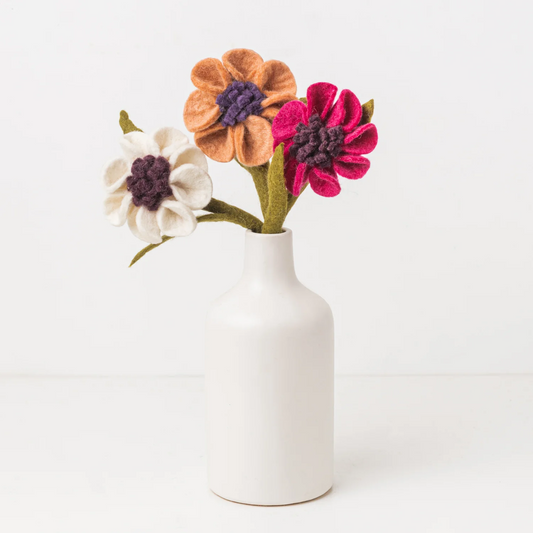 Pink, orange and white felt floral arrangement in a white vase.