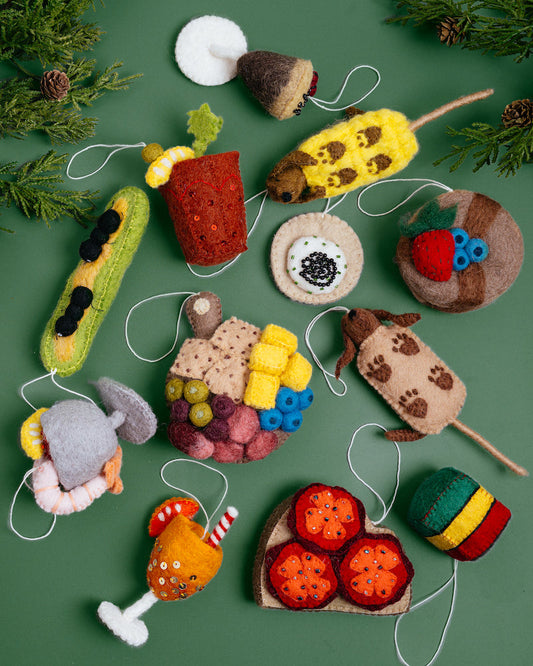 A variety of food related felt ornaments on a green background.